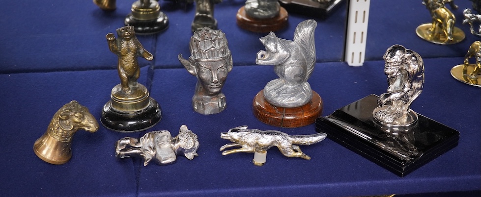 Seven chrome, brass and aluminium car mascots, etc. including an unusual and comical aluminium car mascot in the form of a squirrel holding a nut, together with a standing bear, an Art Deco winged head, a ram, a running